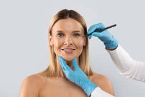 Woman smiling getting marked by surgeon for facelift in Philadelphia, PA