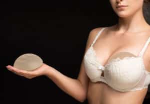 Woman trying on breast implants for breast augmentation in Philadelphia, PA