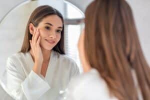 Woman looking in the mirror at her skin after IPL in Philadelphia Main Line